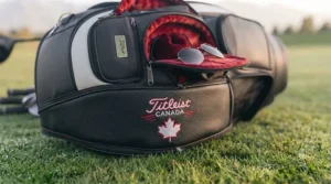 A high-end tour staff golf bag securely positioned on a motorized golf cart at a scenic course in Ontario, Canada.