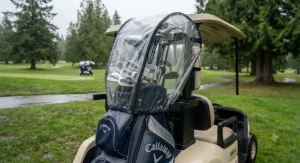 Clear golf bag rain cover fitted securely over a cart bag on a power cart.
