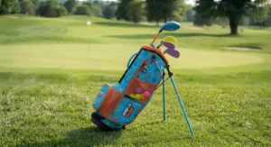 Illustration of a durable, freestanding junior golf bag for toddlers placed on the grass of a golf fairway.