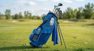 Junior golf stand bag packed with a youth golf club set, standing on a lush green golf course tee box during a sunny summer day.