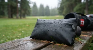 Water droplets beading off a waterproof golf valuables pouch during a damp morning tee time in Canada.